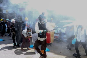 Người biểu tình đeo mặt nạ và kính bảo hộ đối đầu với lực lượng quân đội Myanmar. 