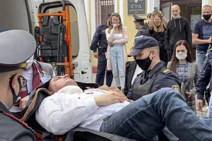 Cảnh sát và nhân viên y tế đưa nhà hoạt động Steffan Latypov lên xe cấp cứu.