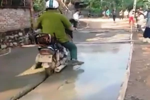 Clip người mặc áo công an chạy xe vào đường bê tông ướt