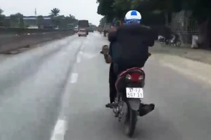 Bị công an triệu tập vì đi xe máy bằng chân, tay dùng di động