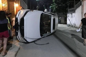 Xe hơi đâm gãy cột điện rồi lật nghiêng giữa đường 