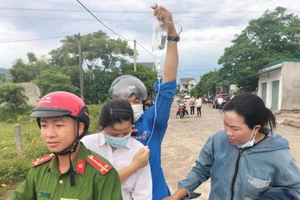 Nữ thí sinh đeo bình truyền nước trên tay đến phòng thi 