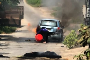 Xe hơi bốc cháy sau khi chạy qua rơm phơi trên đường