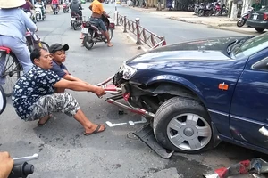 xe cán bẹp và dính luôn dải phân cách vào gầm xe (ảnh HÀ HUY)