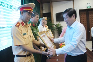 Chủ tịch UBND TP.HCM Nguyễn Thành Phong tặng bằng khen cho các tập thể, cá nhân có thành tích xuất sắc. Ảnh: LÊ THOA
