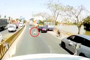 Người đàn ông giả khuyết tật nằm lê lết bên làn đường ô tô vẫy tay ăn xin. (Ảnh cắt từ clip)