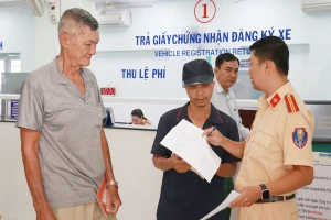 Cán bộ Đội Đăng ký và quản lý phương tiện thuộc Phòng CSGT TP.HCM hướng dẫn người dân thủ tục đăng ký xe. Ảnh: LÊ THOA