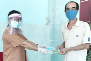 Cán bộ phường Thạnh Xuân, quận 12 chi hỗ trợ cho người lao động tự do. Ảnh: NGUYỄN HIỀN