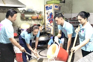 BS Lê Thanh Nga (thứ hai từ trái sang) cùng bạn bè tất bật nấu cơm, cháo phát miễn phí cho bệnh nhân từ mờ sáng. Ảnh: TRẦN MINH