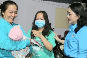 Bà Nguyễn Kim Loan, Chủ tịch LĐLĐ tỉnh Bình Dương, thăm hỏi và tặng quà cho công nhân gặp khó khăn. Ảnh: LÊ ÁNH