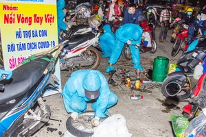 Nhóm của anh Phước sửa xe cho người dân chạy khỏi tâm dịch. Ảnh: NVCC
