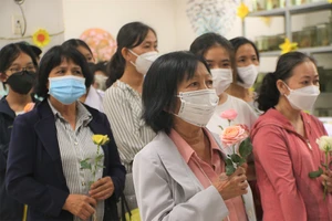 Bà Tăng Thị An Nhi cầm đóa hoa hồng để tri ân người em đã hiến xác cho khoa học. Ảnh: THẢO PHƯƠNG