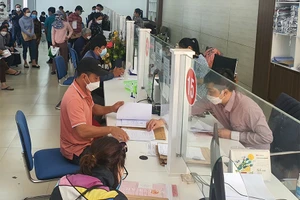 Một số thủ tục hành chính hiện nay vẫn yêu cầu người dân phải có giấy xác nhận nơi cư trú thay cho sổ hộ khẩu. Ảnh: TẤN VIỆT