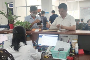 Người dân đến cơ quan BHXH tại TP.HCM thực hiện các thủ tục hành chính liên quan đến BHXH, BHYT. Ảnh: NGUYỄN HIỀN