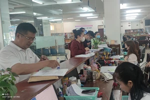 Người lao động làm thủ tục liên quan đến chế độ BHXH tại cơ quan BHXH TP.HCM. Ảnh: NGUYỄN HIỀN