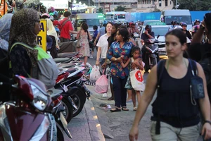 Vỉa hè bị trưng dụng để xe máy, người đi bộ phải đi xuống lòng đường ở trung tâm TP.HCM . Ảnh: HOÀNG GIANG