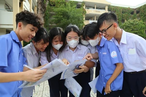 Học sinh tham dự kỳ thi tuyển sinh vào lớp 10 tại TP.HCM dò bài sau khi rời phòng thi. Ảnh: HOÀNG GIANG