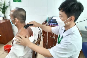 Một bệnh nhân đang được điều trị bằng điện xung kết hợp siêu âm. Ảnh: TRẦN NGỌC