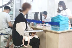 Người dân đến văn phòng công chứng thực hiện các thủ tục công chứng. Ảnh: NGUYỄN HIỀN