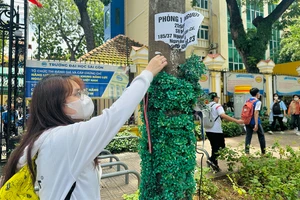 Trụ điện được quấn cỏ nhựa sau thời gian sẽ bong tróc, gây mất mỹ quan đô thị. Ảnh: KHÁNH TOÀN