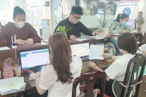 Người dân đang thực hiện các thủ tục liên quan đến BHXH ở cơ quan BHXH TP.HCM. Ảnh: NGUYỄN HIỀN