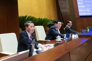 Các đại biểu bấm nút thông qua Luật Lực lượng tham gia bảo vệ an ninh trật tự ở cơ sở. Ảnh: QH