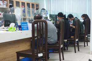 Người dân đến cơ quan BHXH quận 3 làm thủ tục liên quan đến BHXH, BHYT. Ảnh: NGUYỄN HIỀN