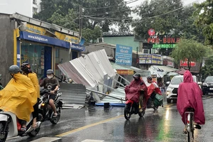 Chiều 18-7, một bảng hiệu trên đường Nguyễn Văn Quá (phường Đông Hưng Thuận, quận 12) bất ngờ đổ sập xuống đường do mưa lớn. Ngay sau đó, lực lượng chức năng của địa phương đã có mặt, xử lý hiện trường. Ảnh: TRẦN MINH