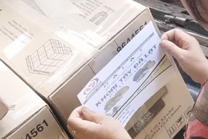 Người của vựa nông sản cùng các công nhân dán tem khoai tây Đà Lạt lên thùng khoai tây Trung Quốc để bàn giao cho khách. Ảnh trong bài: MINH HẬU - TỰ SANG