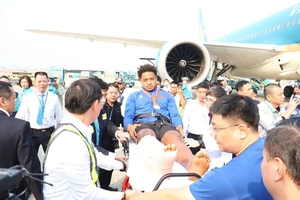 Xuân Son nằm trên băng ca cứu thương khi về Việt Nam. Ảnh: TÂM NINH