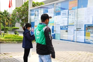 Người lao động đang đọc các thông tin tuyển dụng lao động cuối năm tại KCX Tân Thuận, quận 7, TP.HCM. Ảnh: VÕ THƠ