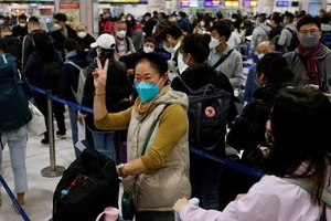 Hành khách tại sân bay quốc tế thủ đô Bắc Kinh sau khi Trung Quốc tuyên bố mở cửa trở lại hồi 8-1. Ảnh: REUTERS