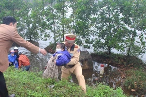 CSGT giúp đỡ hai mẹ con bị rơi xuống vũng nước sâu