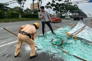 CSGT TP.HCM giúp người dân dọn kính vỡ ở quốc lộ 1, TP Thủ Đức
