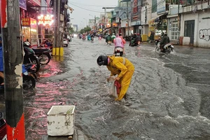 Các công nhân vớt rác, giúp khu vực Thủ Đức thoát nước nhanh sau cơn mưa lớn