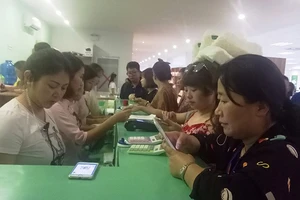 Khách Trung Quốc thanh toán qua máy POS tại một cửa hàng ở TP Nha Trang. Ảnh: TL