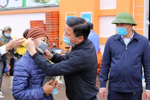 Bí thư Tỉnh ủy tỉnh Thanh Hóa tặng và đeo khẩu trang cho người dân khi kiểm tra chống dịch ở những nơi đông người. Ảnh: Đ.TRUNG