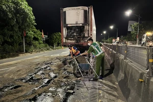 Công an cùng người dân hì hục dọn vệt dầu loang trên QL1A lúc nửa đêm