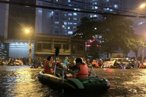 Mưa kỷ lục: Dân bơi thuyền ra phố để mang xe máy vào nhà