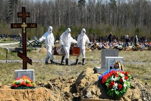 Công nhân làm việc ở nghĩa trang ngoại ô thành phố St Petersburg mặc đồ bảo hộ (Ảnh chụp ngày 6-5-2020). Ảnh: AFP