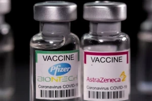 Lọ vaccine COVID-19 của Pfizer/BioNTech (trái) và của AstraZeneca. Ảnh: REUTERS