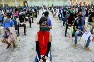 Người dân chờ tiêm vaccine ngừa COVID-19 ở thủ đô Jakarta (Indonesia). Ảnh: REUTERS