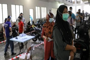 Người dân Malaysia xếp hàng chờ xét nghiệm COVID-19. Ảnh: REUTERS