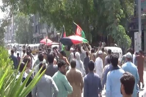 Người dân cầm quốc kỳ Afghanistan biểu tình phản đối Taliban. Ảnh: REUTERS