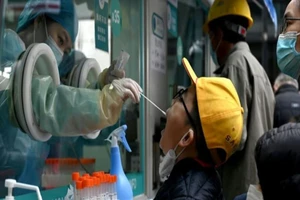 Nhân viên y tế Trung Quốc xét nghiệm COVID-19 cho người dân. Ảnh: AFP