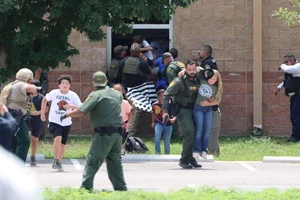 Trẻ em chạy đến nơi an tòa sau khi thoát ra bằng cửa sổ trong vụ xả súng tại trường tiểu học Robb, bang Texas. Ảnh: REUTERS