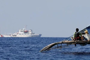 Ngư dân Philippines quan sát tàu Cảnh sát biển Trung Quốc tuần tra gần bãi cạn Scarborough. Ảnh: REUTERS
