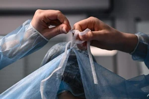 Y tế mặc thiết bị bảo hộ trước khi điều trị cho bệnh nhân COVID-19. Ảnh: AFP