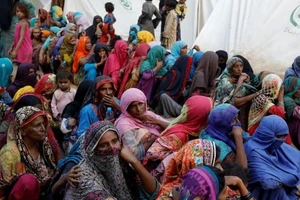 Những người phụ nữ phải di dời vì lũ lụt chờ được phát thực phẩm trong trong một trại tị nạn ở thành phố Sehwan, tỉnh Sindh, Pakistan, ngày 30-9. Ảnh: REUTERS