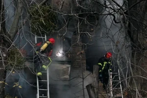 Lính cứu hỏa Ukraine dập lửa một tòa chung cư bị Nga dội tên lửa tối 15-11. Ảnh: REUTERS